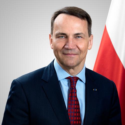 Minister Spraw Zagranicznych Radosław Sikorski na tle flagi Polski